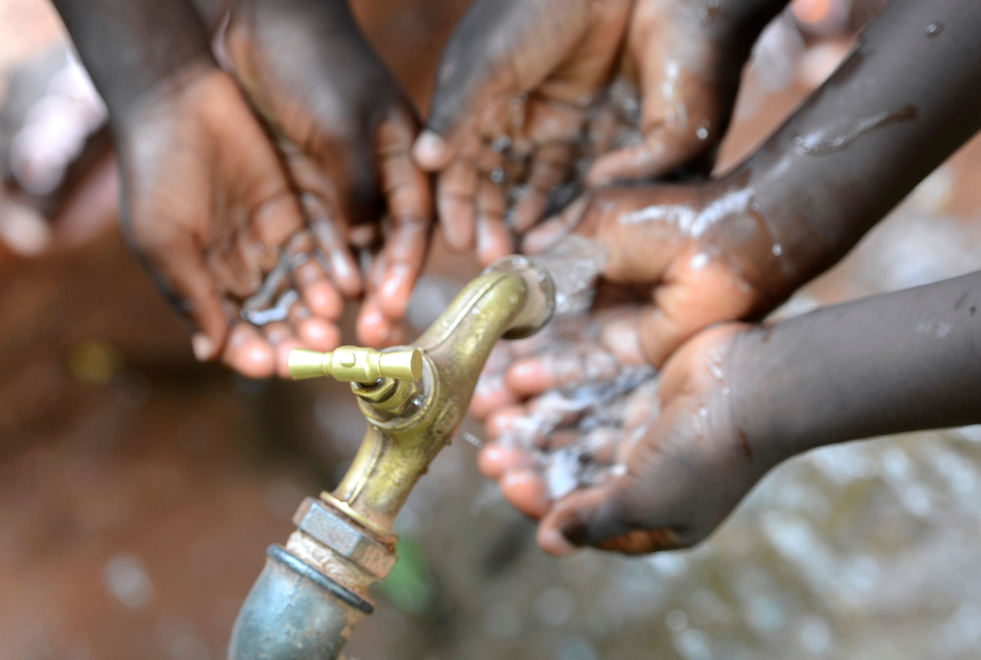 Hands of African Children Cupped under Tap Drinking Water Malnutrition
