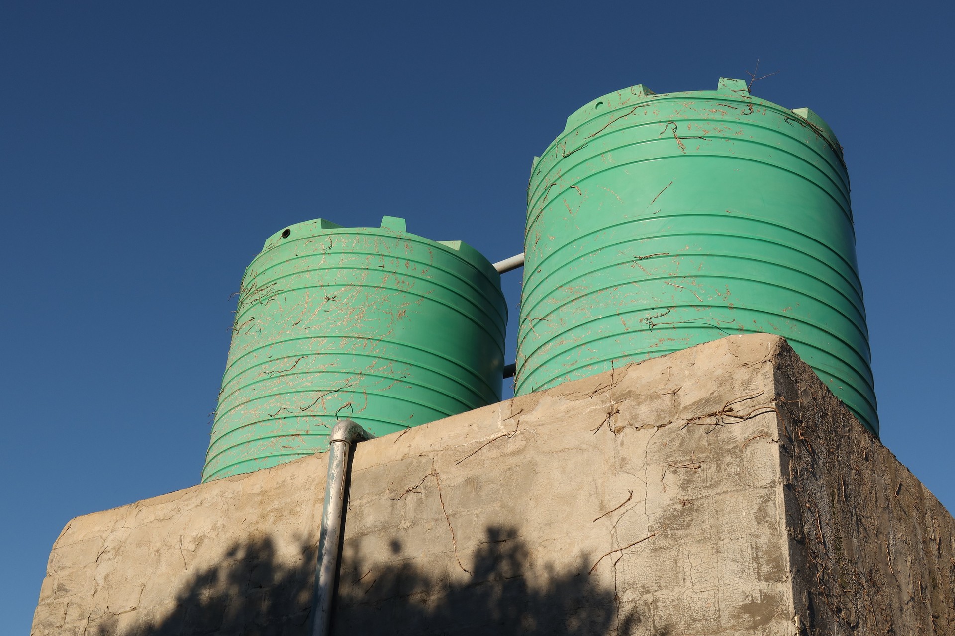 A plastic residential water tank that harvests water from a roof.