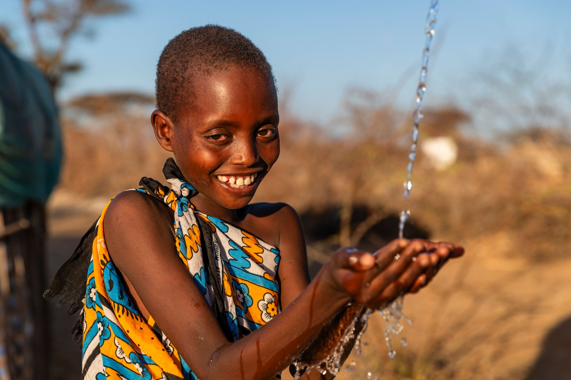 African young boy drinking fresh water on savanna, East Africa
